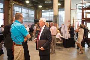 Two men speaking at the gallery celebration.